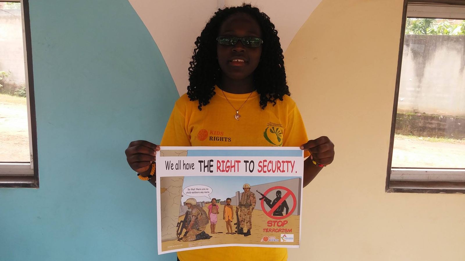 A young person holding a poster about the right to security