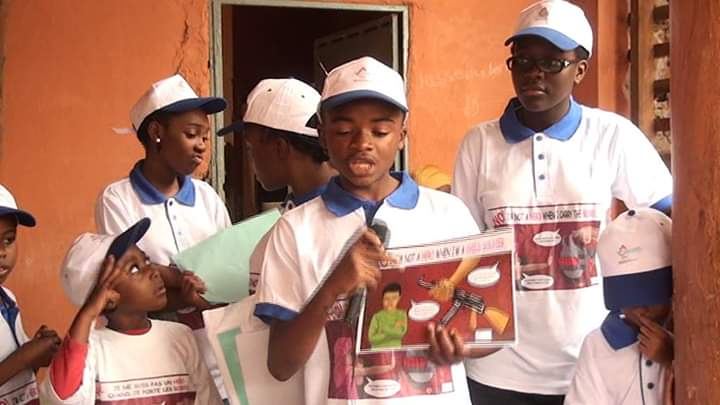 Young people in caps reading a poster together